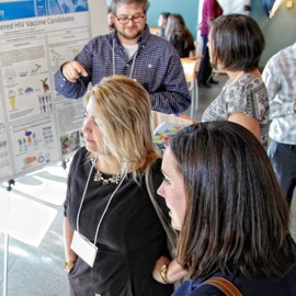 Attendees listen to a student speak about her research.