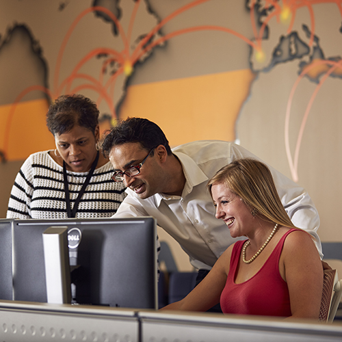 Students gather behind a computer.