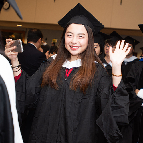 graduate smiling and waving