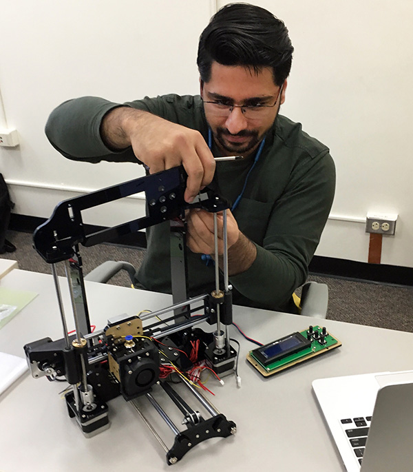 Himanshu Nagpal, MBA’19, works on assembling his 3D printer.