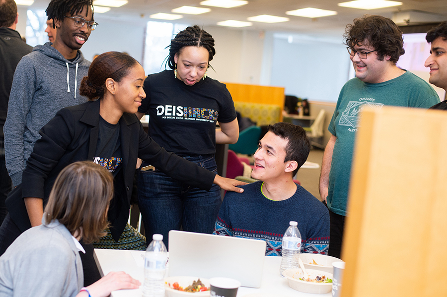 Team members eat lunch and talk.