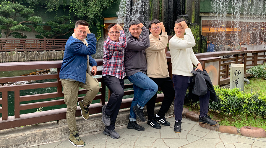 Four fellows pose in a garden.