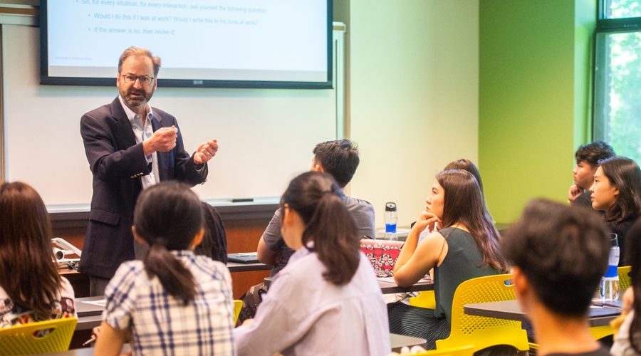 Economics Prof. George Hall speaks to new students.