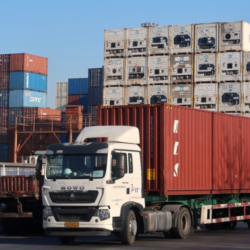 A big rig truck parked near shipping containers.