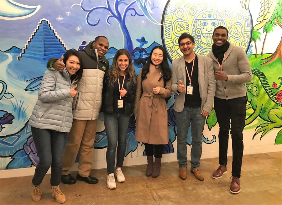 Students pose by a mural inside Facebook.