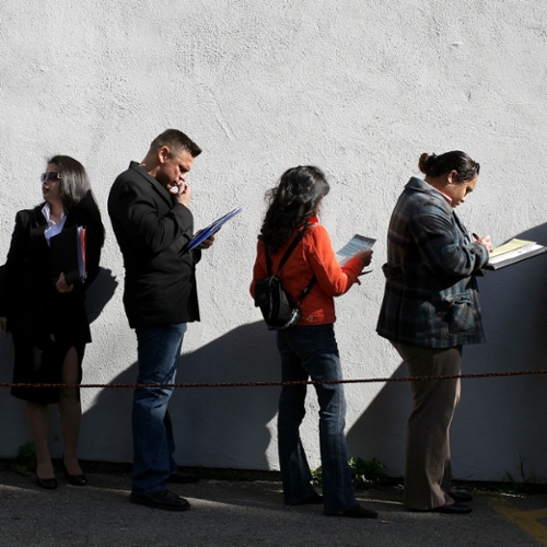People waiting in line for job postings.