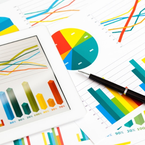 Scattered papers with colorful charts and graphs.