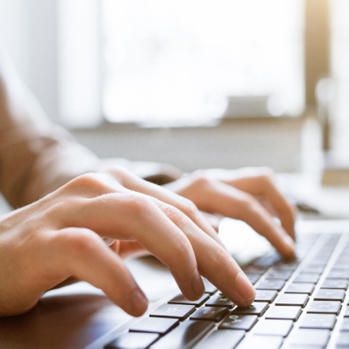 Hands typing on a laptop.