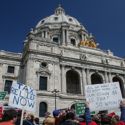 People protesting tax policy outside a state capitol building