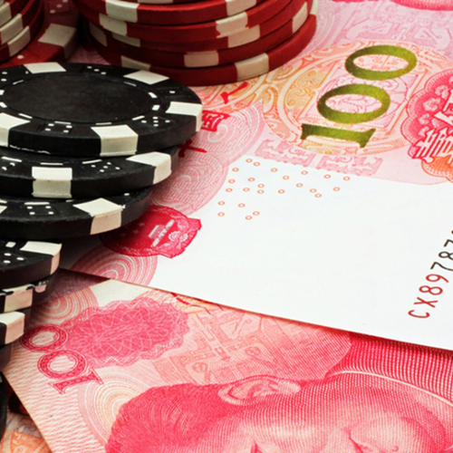 Poker chips sitting on yuan notes.