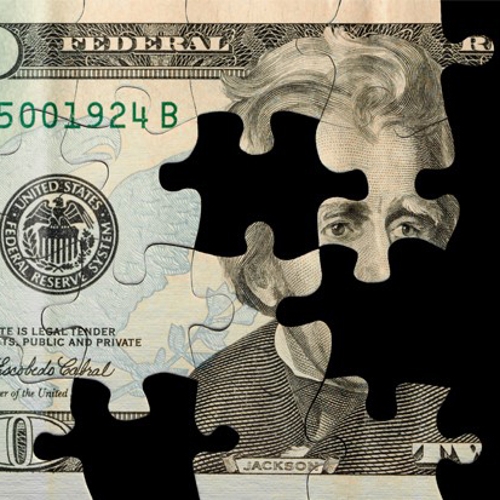 A 20 dollar bill cut like a jigsaw puzzle with pieces missing.