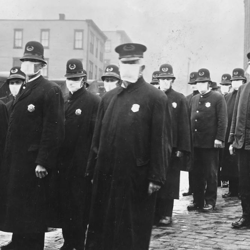 A picture of police officers on the street wearing masks circa 1918.