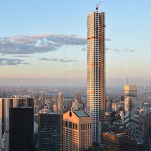The supertall 432 Park Avenue in New York City, thin and square and towering above surrounding buildings, under construction.