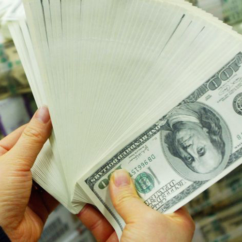 A close up of a hand holding a fan of 100-dollar bills.