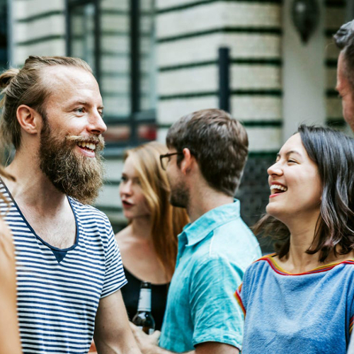 A group of students talk together on a campus.