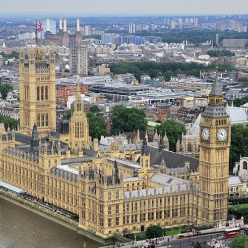A photo of Westminster Palace, with London in the background, shot from the air.