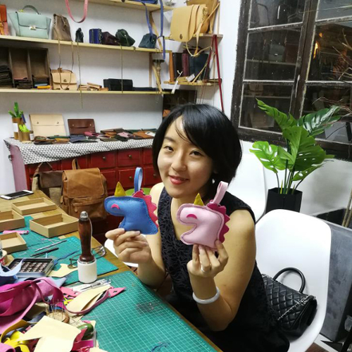 Xiaoqi Wu displays two felt unicorn toys she made..