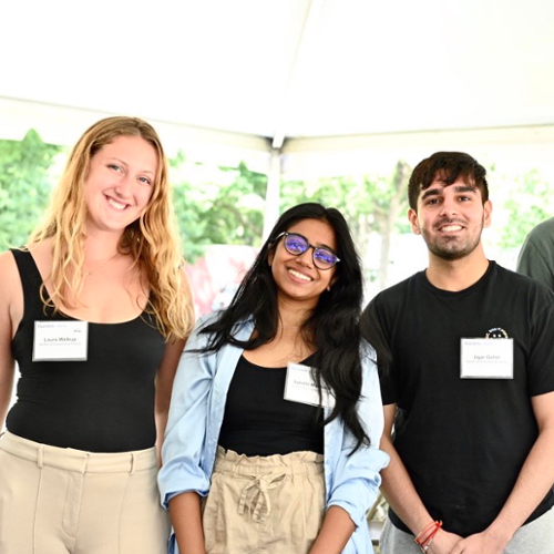 Three students pose smiling at orientation.