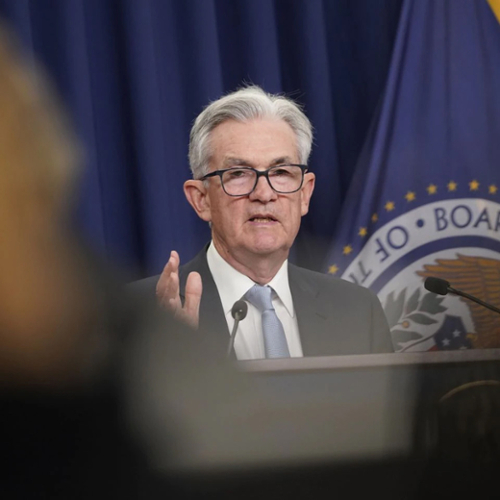 A photo of Fed Chair Jerome Powell speaking at a podium.