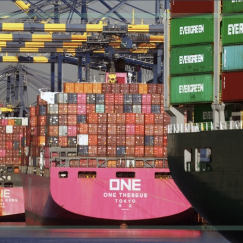 Two large container ships loaded with containers wait at a port to be unloaded.