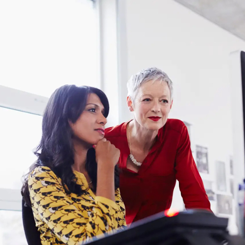 A bright image to two women working together at a computer.