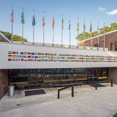 Photo of The International Business School decorated with dozens of flags from across the world.
