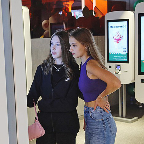 Two young women order from a kiosk at what used to be a McDonald's in Russia.