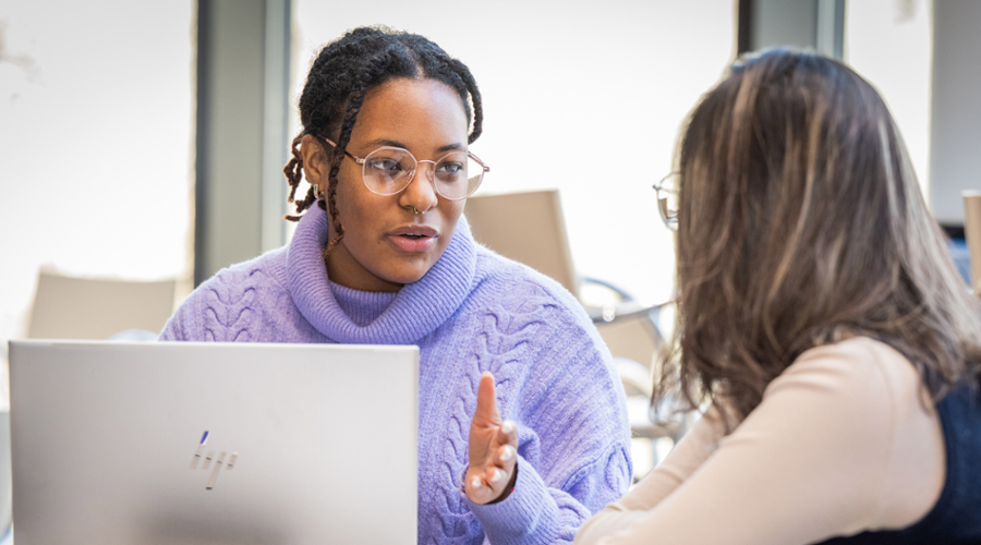 A picture of Rebecah Kennedy talking to another student.