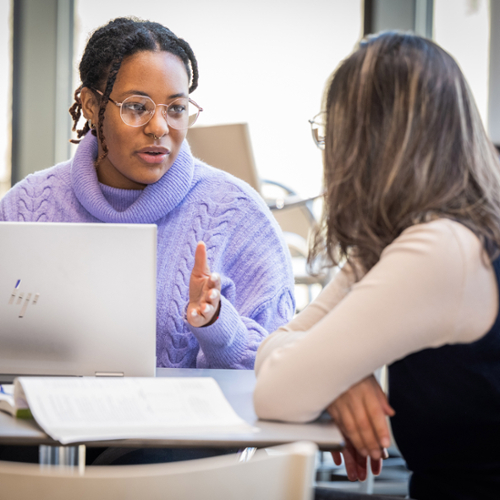 A picture of Rebecah Kennedy talking to another student.