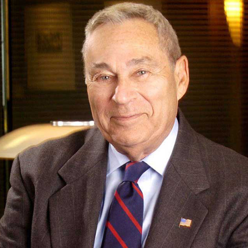 A portrait of Richard Rosenberg in a suit with an office in the background.