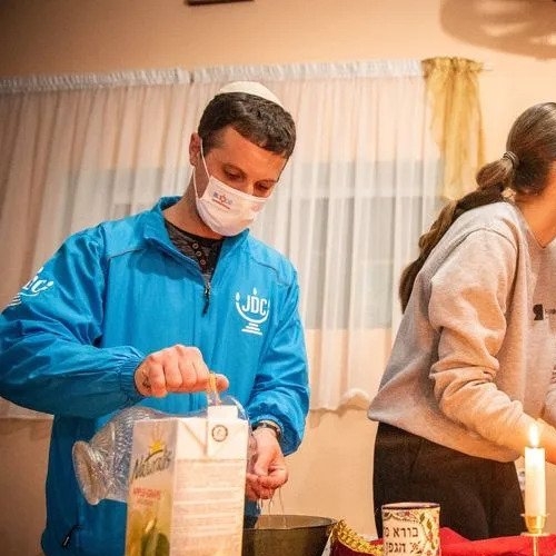 Image of Doron Shapir ritually washing his hands as he prepares for a Kabbalat Shabbat for refugees from Ukraine with the Moldovan Jewish community