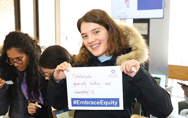 Student celebrating with a selfie card message for International Women's Day hosted by the International Business Women's Club.