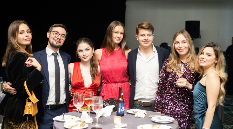 Students pose around a table at the Global Gala.