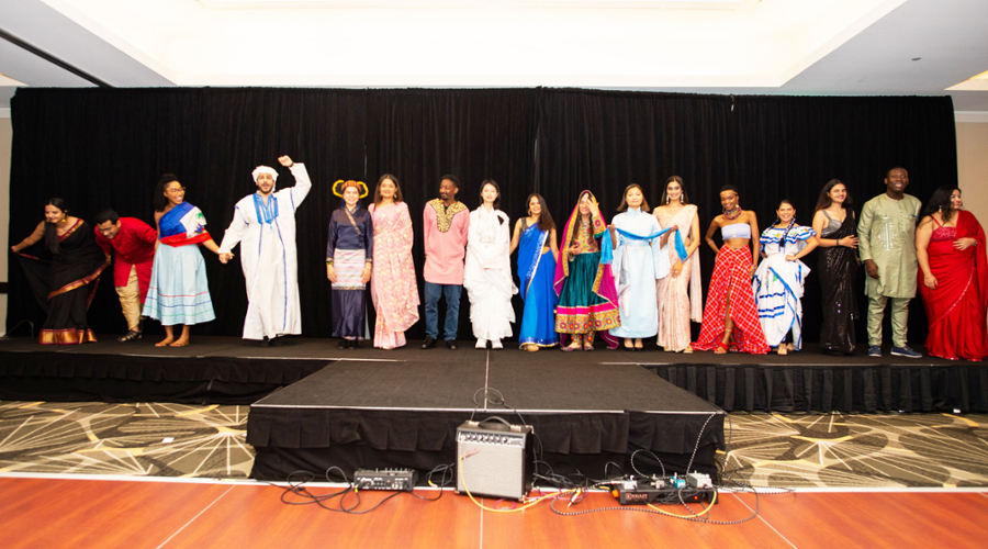 Seventeen of the students who wore cultural dress to the Global Gala stand on stage together for the audience.