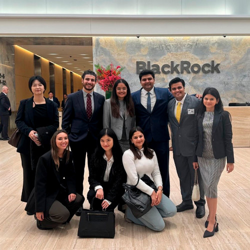 Students pose for a photograph in business dress in the cavernous marble lobby of BlackRock.