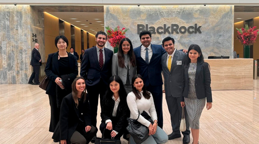 Students pose for a photograph in business dress in the cavernous marble lobby of BlackRock.