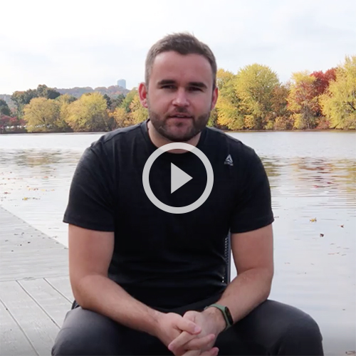 Selim Blliku, MBA'21 sitting alongside the Charles River