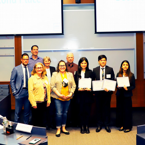 The author and her team holding their group's certificates and posing with the judges and Dean Kathryn Graddy.