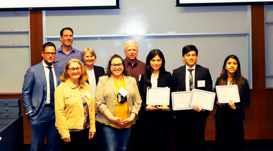 The author and her team holding their group's certificates and posing with the judges and Dean Kathryn Graddy.