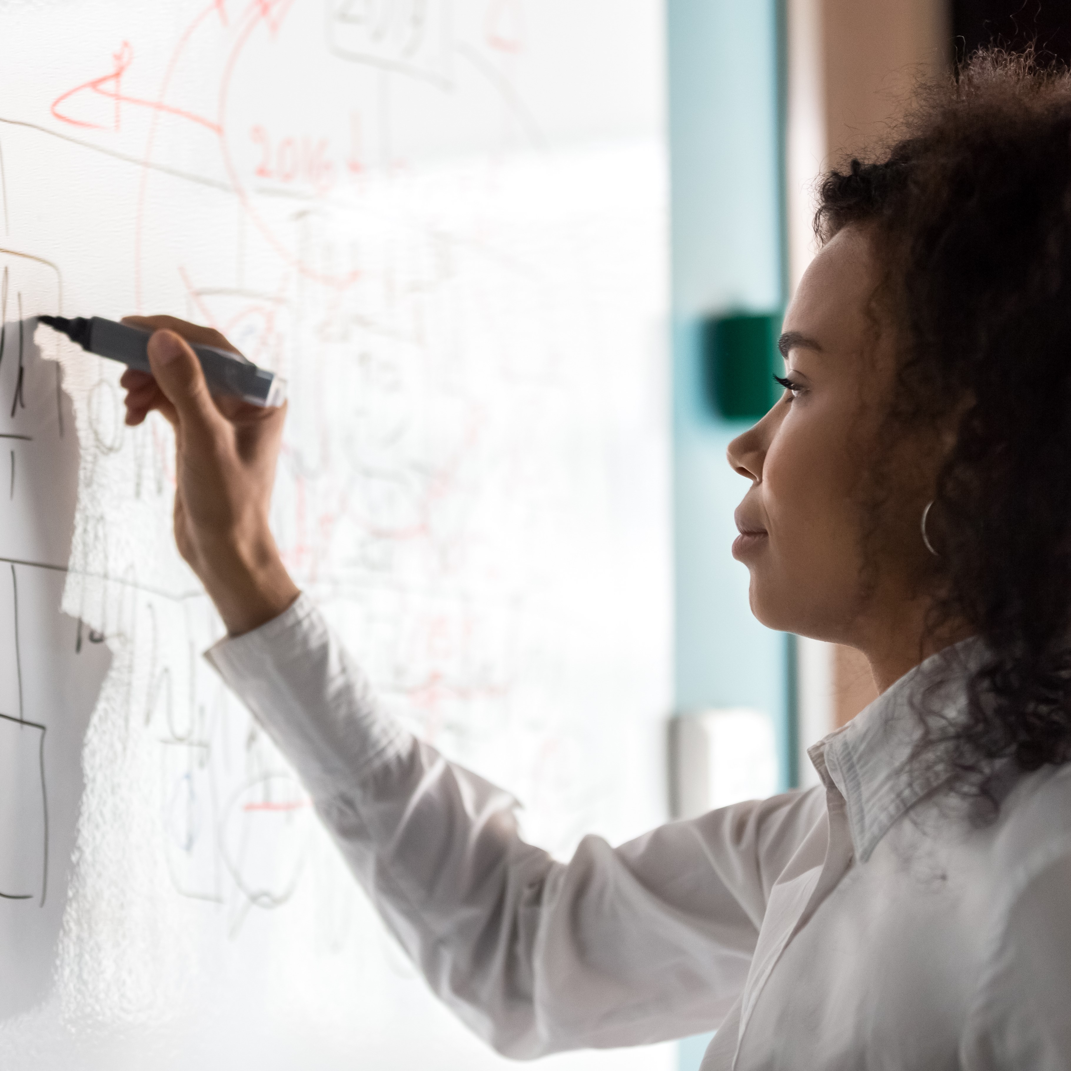 Person writing on a white board