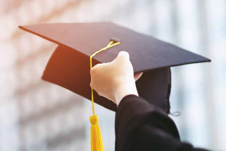 Person holding a graduation cap.