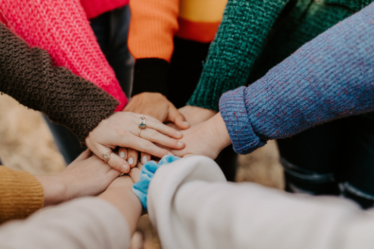 Hands joined in the middle of a circle in a sign of teamwork