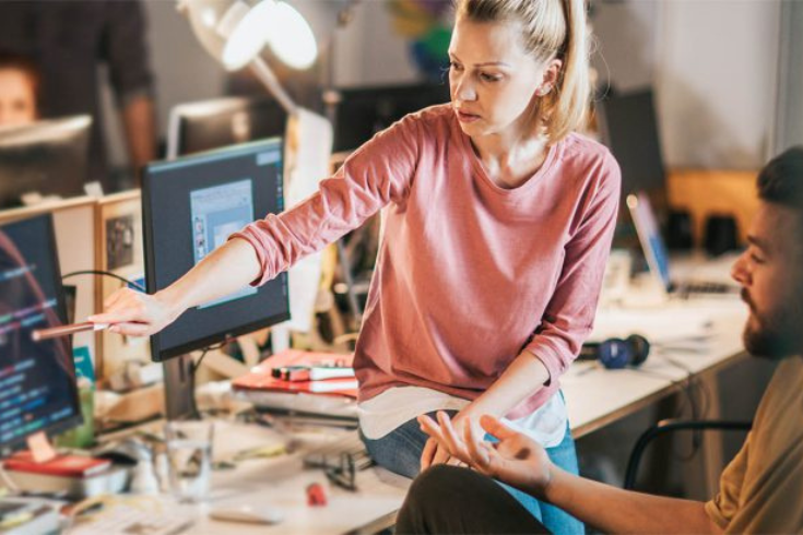 Two engineers working at a computer monitor