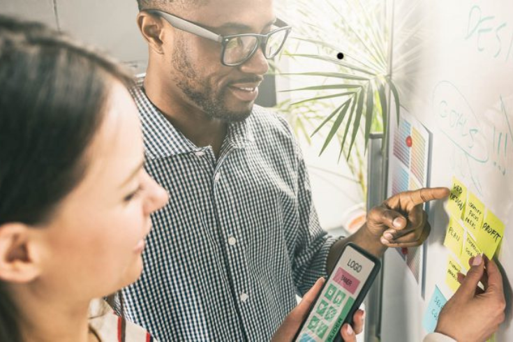 Two people collaborating on a UX design using sticky notes