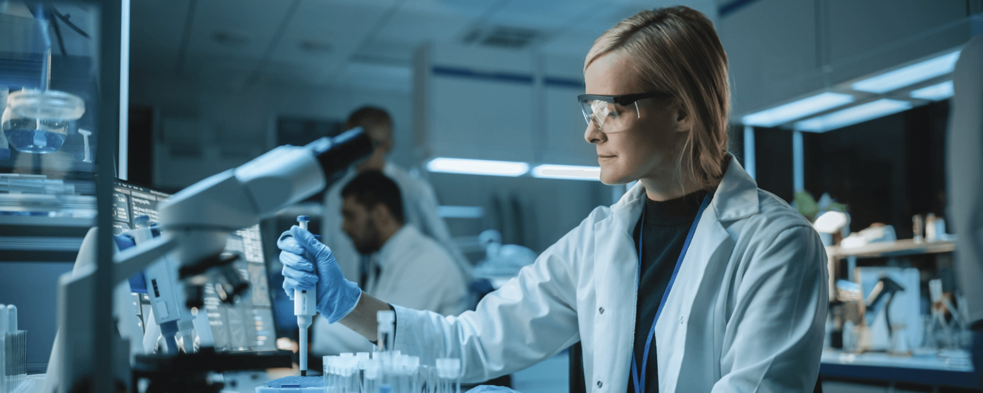 woman in lab coat works with pipette and lab samples 