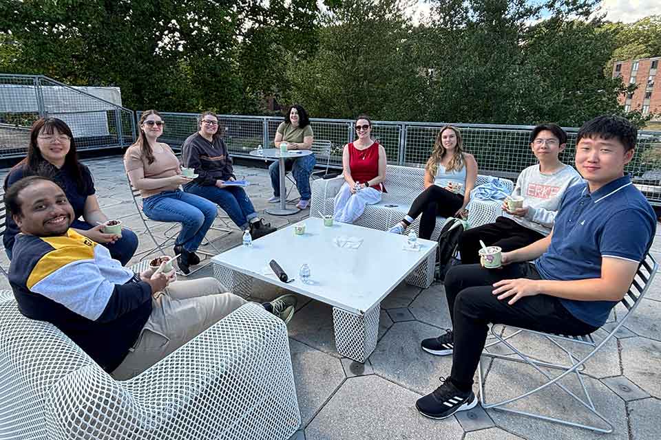 Graduate students sitting outside on a patio, enjoying ice cream.