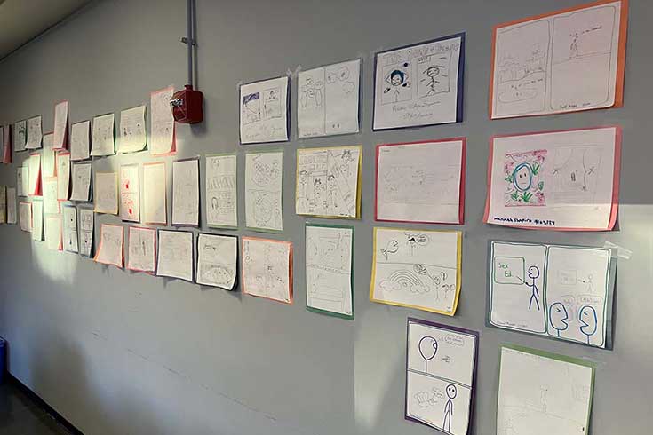 A wall covered in hand-drawn comics.