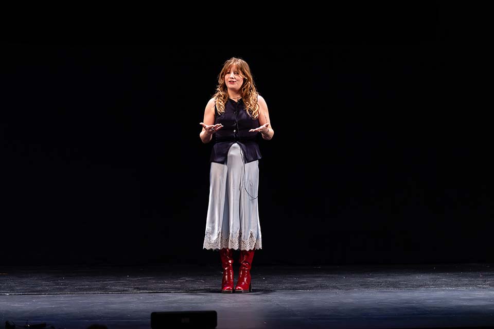 Cali McKenzie stands onstage.