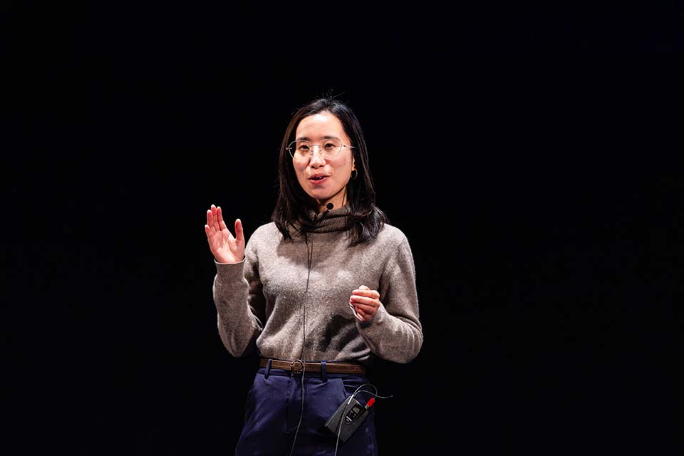 Tong Lin stands speaking.