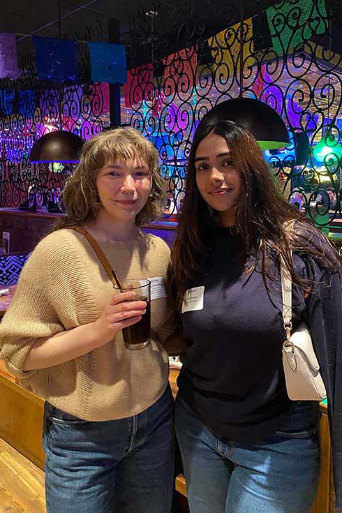 An alum and student stand together in Margaritas Mexican Restaurant.